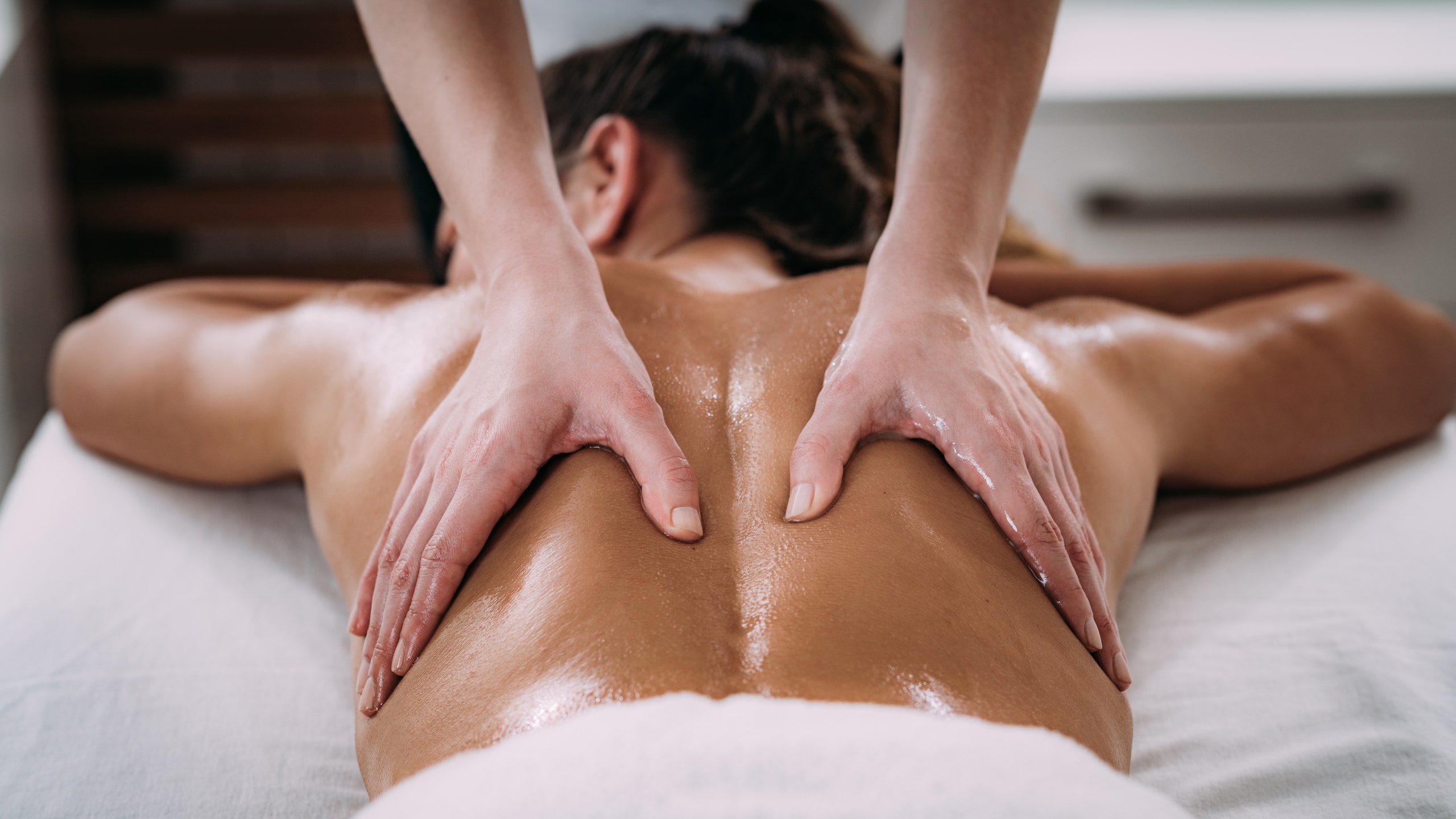 What are the benefits of using essential oils for massage therapy?